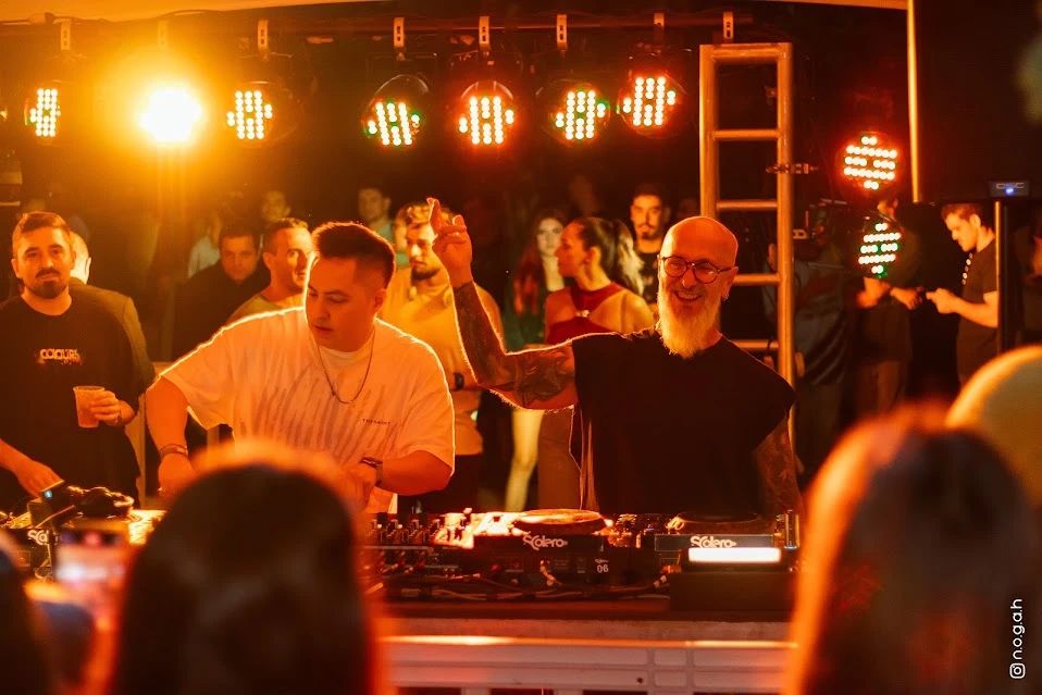 Masaaki e NeoClassic juntos na cabine de DJ, sob as luzes da tenda
